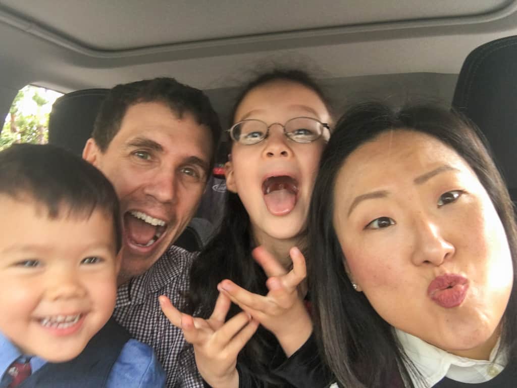 family in car doing selfie with silly faces