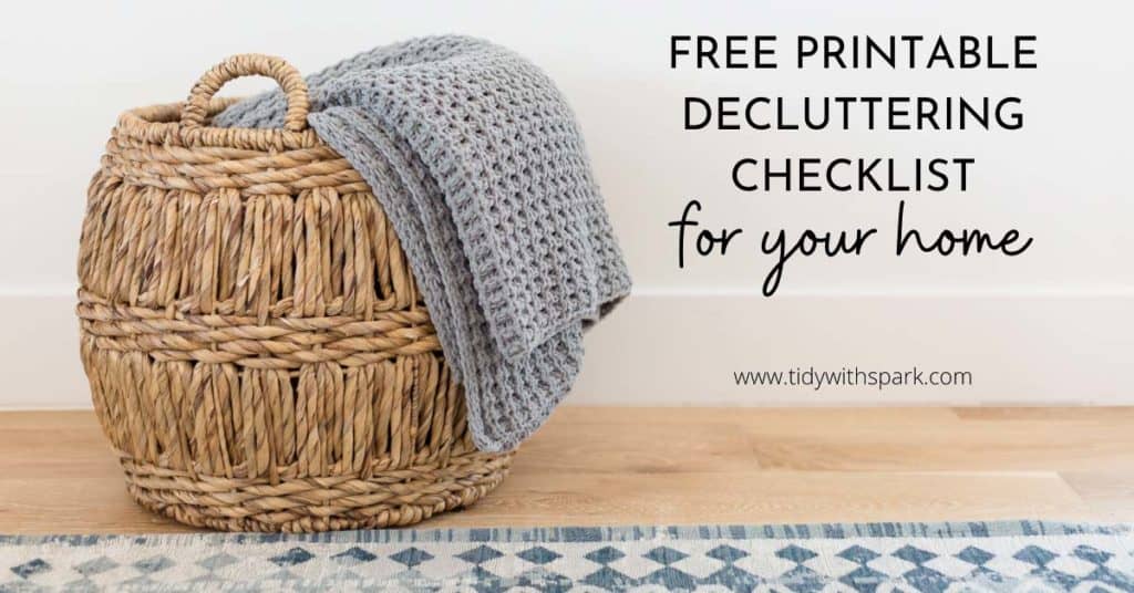 woven basket with folded blanket laid on side with text overlay "free printable decluttering checklist for your home"