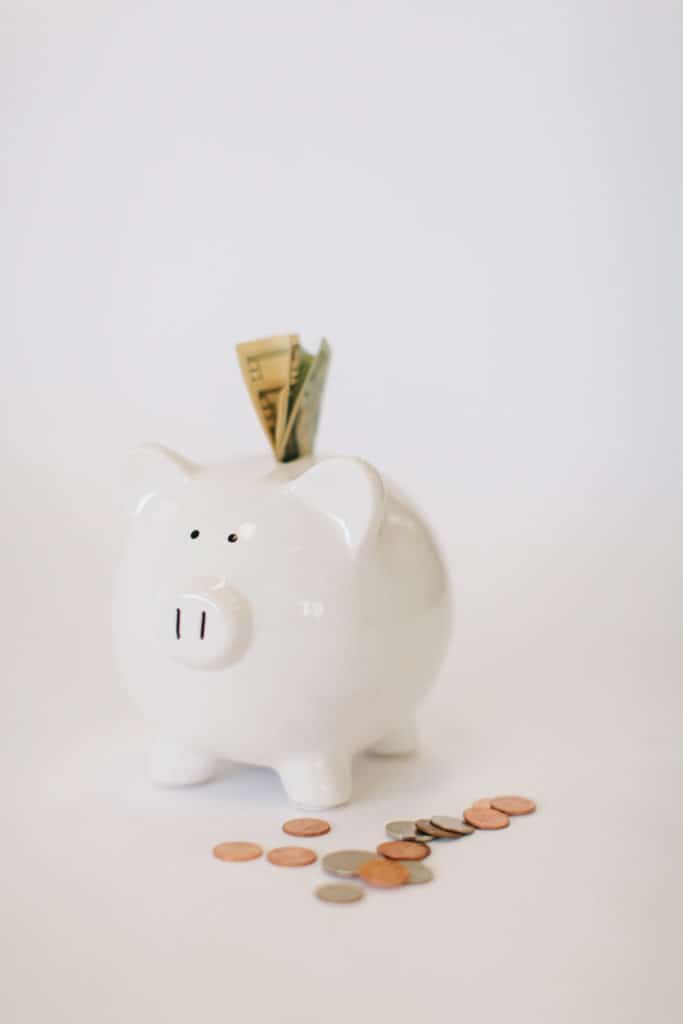 ceramic piggy bank with bills folded into the coin slot