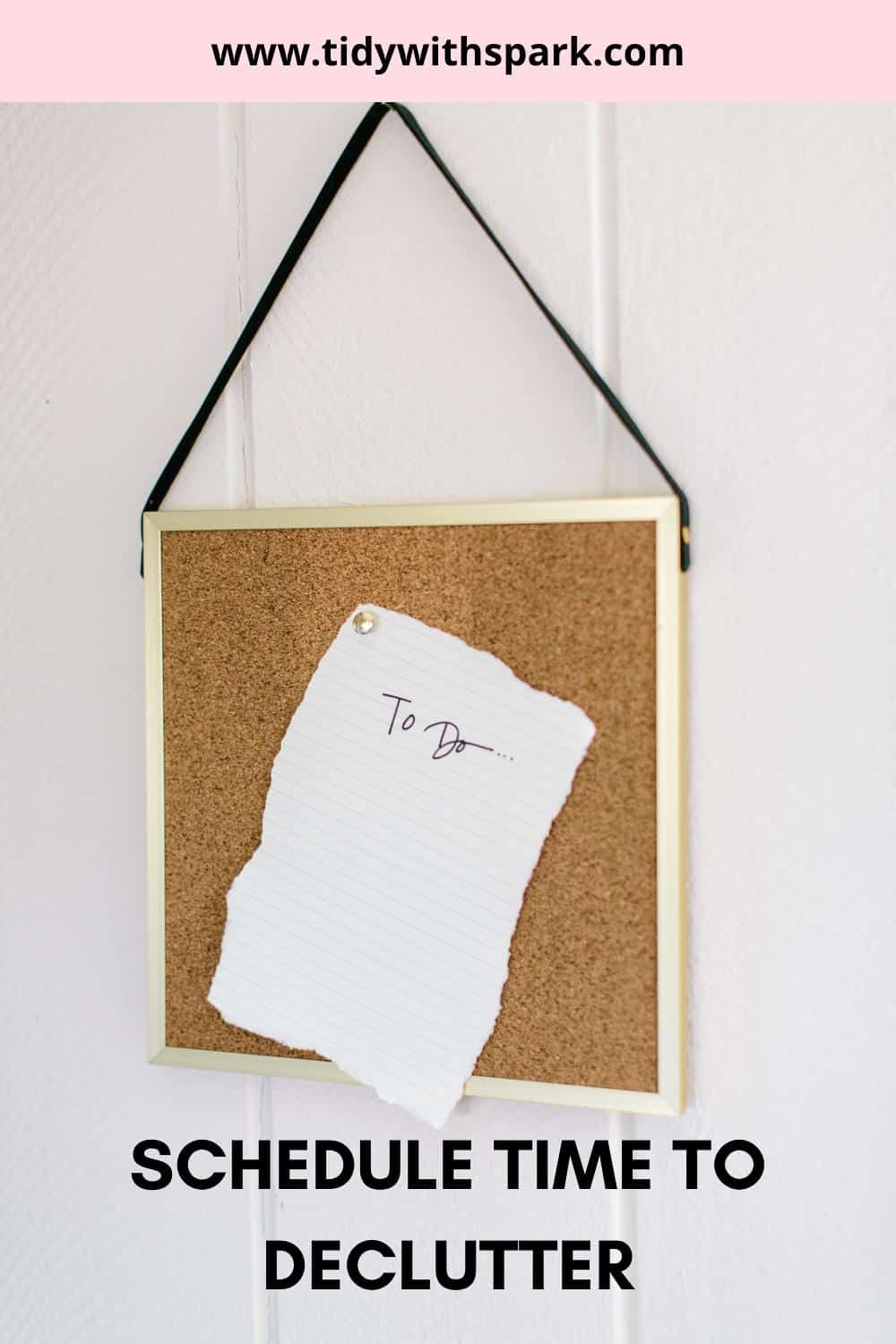 Cork board hung on wall with black string with to-do note pinned with text overlay "schedule time to declutter"